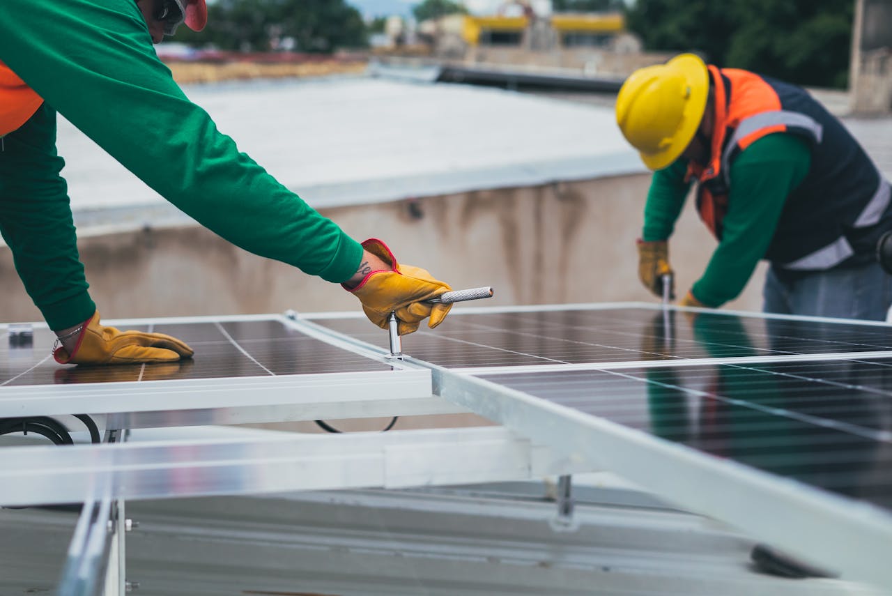NilePhase engineers torquing solar panels onto a roof in Uganda